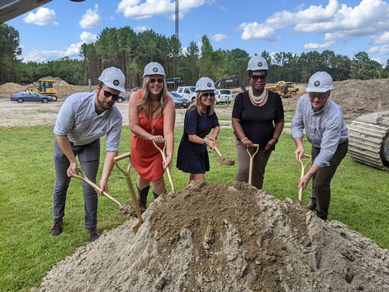 Community Leaders with shovels moving dirt for groundbreaking ceremony.